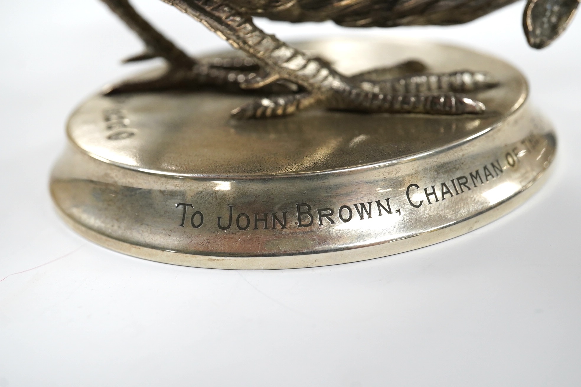 An Elizabeth II silver presentation cockerel, on a circular base with engraved inscription, by Garrard & Co Ltd, London, 1953, overall height 14cm, weighted. Condition - fair to good